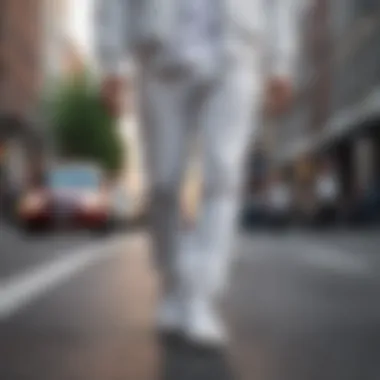 Fashionable person in white sneakers walking on city street